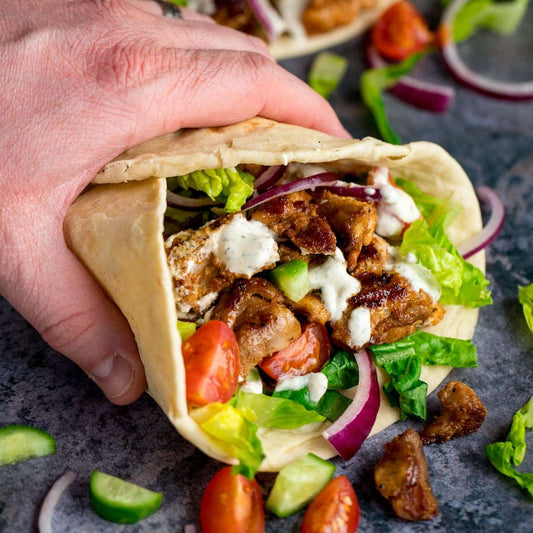 Halal chicken shawarma wrapped in warm pita with tahini sauce and crisp vegetables