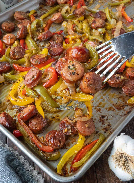 Halal BBQ sausage roasted with bell peppers, onions, and potatoes on a sheet pan